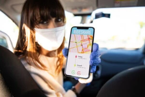 Car sharing driver showing destination to passengers on smart phone.