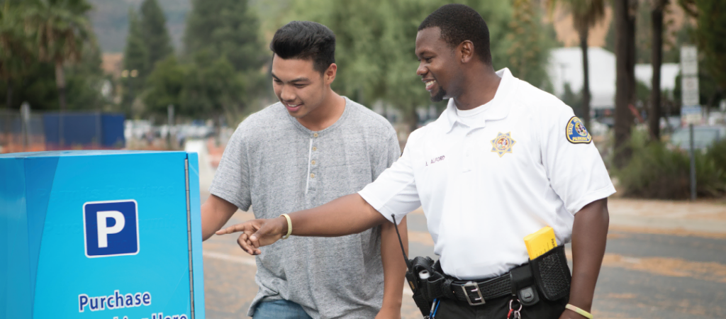 PECP Parking Enforcement & Compliance Professional and a Student at a parking meter